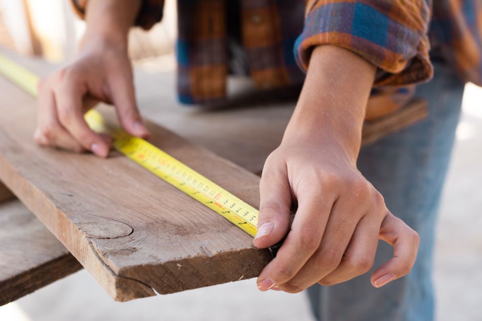 Field technician measuring wall rough-in for hospital MEP furniture interference check