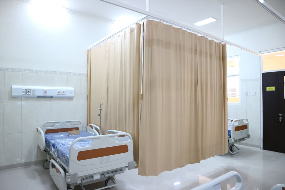 Full-scale guestroom mock-up with bed, IV pole, and wheelchair for clinical workflow ergonomic testing
