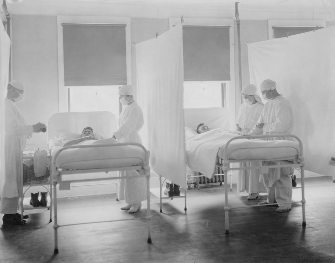 Medical staff attending to patients in hospital beds.