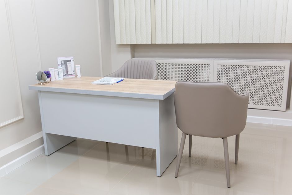 Minimalist medical office with a modern desk and chairs, perfect for healthcare settings.