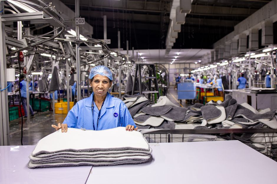 Factory worker inspecting upholstered hospital seating for fire compliance