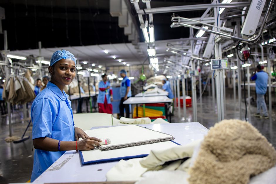 Factory engineer inspecting an adult medical bed frame against IEC 80601-2-52:2026 requirements on a production line